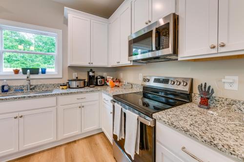 a kitchen with white cabinets and a stove top oven at 4 Mi to Auburn University Townhome with Fenced Yard in Opelika