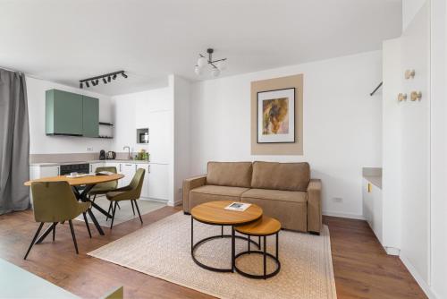 a living room with a couch and tables and a kitchen at Hubix Suites - City of Mara in Timişoara