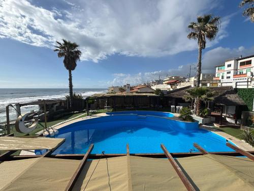 a large blue swimming pool next to the beach at Golden Home in Anzio