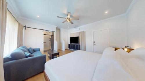 a bedroom with a bed and a couch and a ceiling fan at The Surf Club in Ocean City