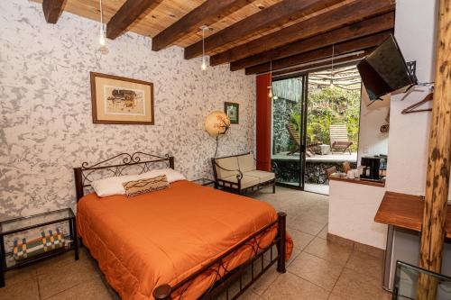 a bedroom with a bed and a tv in a room at Tecuán-Calli in Tepoztlán