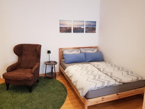 une chambre avec un lit et une chaise dans l'établissement Apartment Ferienglück - Zentraler Rückzugsort, à Neuruppin