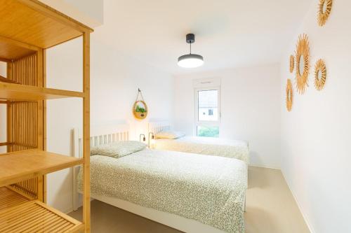 - 2 lits dans une chambre blanche avec une échelle dans l'établissement 76 m2 apartment with rooftop terrace, à Zillisheim