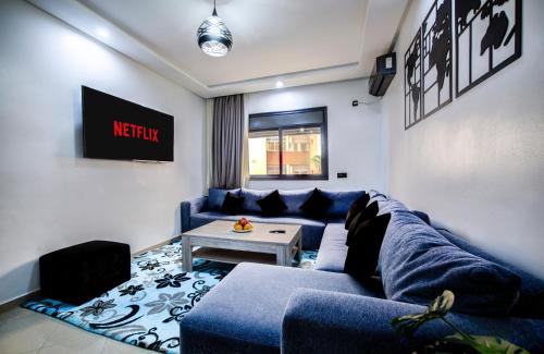 Una sala de estar con un sofá azul y una mesa. en Tranquil Retreat Amidst in Agadir, en Agadir