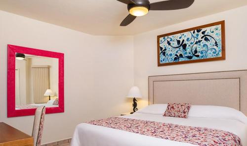 una camera da letto con un letto e uno specchio di 2BD Standard Suite at Villa Del Palmar Cabo a Cabo San Lucas