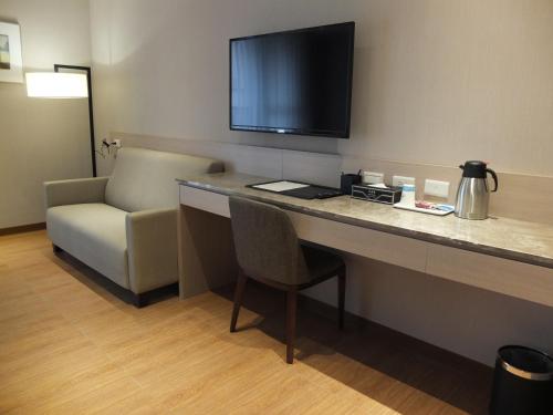 a hotel room with a desk with a chair and a television at VeryGood Business Hotel in Huatan