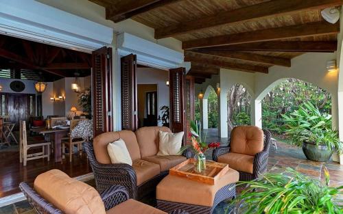 ein Wohnzimmer mit einer Couch und Stühlen und einem Tisch in der Unterkunft Eden's Gate Oceanside Estate in Wesley