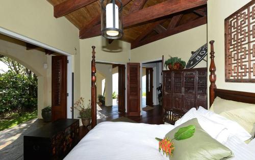 ein Schlafzimmer mit einem Bett mit einem hölzernen Kopfteil in der Unterkunft Eden's Gate Oceanside Estate in Wesley