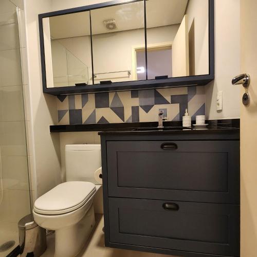 a bathroom with a toilet and a sink with a mirror at FLATS - DUO JK in Sao Jose do Rio Preto