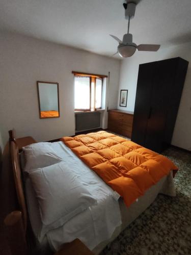 a bedroom with a large bed with an orange blanket at Appartamento l'ara in Scanno