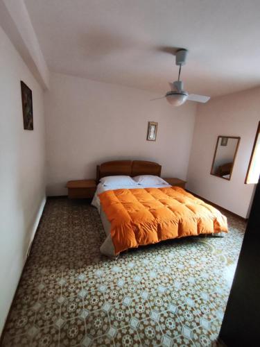 a bedroom with a bed with an orange blanket at Appartamento l'ara in Scanno