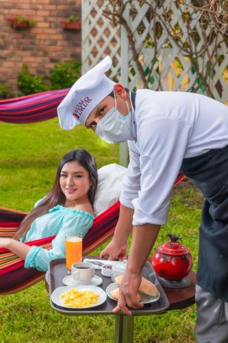 een man met een masker en een tafel met eten bij Hotel Tartar in Cajamarca