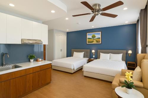 two beds in a hotel room with a kitchen at El Ocaso - Phu My Hung in Ho Chi Minh City