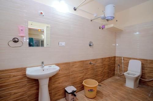 a bathroom with a sink and a toilet at The Peacock Village Eco Resort & Spa in Amrutūr