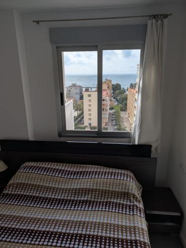 a bedroom with a bed and a large window at Remolins Bloque 2 9B Benicàssim zona Torreón in Benicàssim