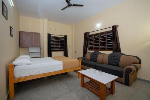 a living room with a bed and a couch at The Peacock Village Eco Resort & Spa in Amrutūr