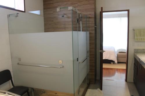 Casa Blanca HaciendaCasa de Campo 15 people with a pool的一间带玻璃淋浴间的浴室和一间卧室