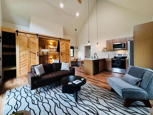 ein Wohnzimmer mit einem Sofa und Stühlen sowie eine Küche in der Unterkunft Hiker's Haven at Three Suns Cabins in Slade