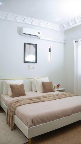 a white bedroom with a large bed in a room at La maison d'Emma in Pointe-Noire