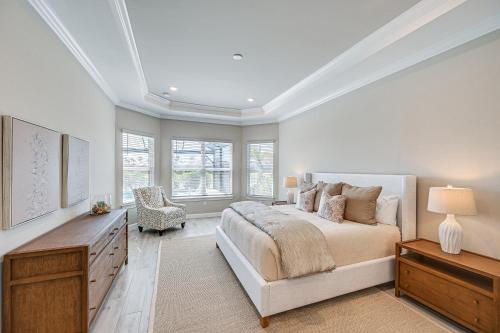 a bedroom with a bed and a dresser and windows at Golf, Swim, Shop and More Luxury Retreat in Naples! in Naples