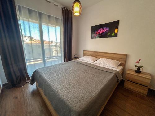 a bedroom with a bed and a large window at Sea & Stone Edge Suites in Dobra Voda