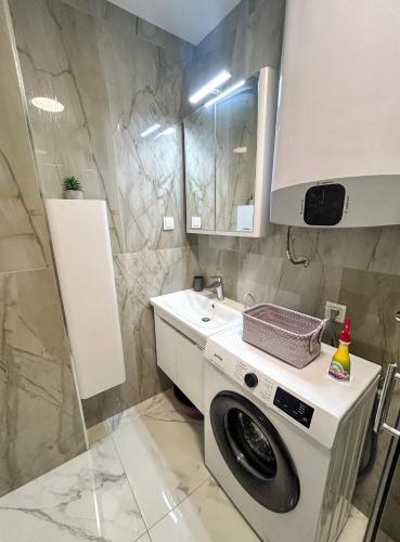 a bathroom with a washing machine and a sink at Sea & Stone Edge Suites in Dobra Voda