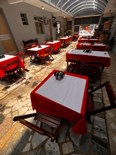 a row of tables in a room with red tables at POUSADA MIRAMAR in Arraial do Cabo