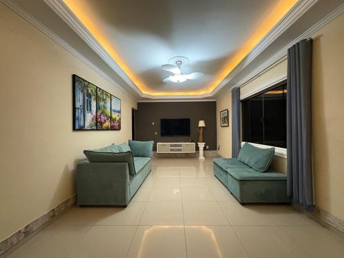 a living room with two couches and a television at Casa com piscina in São Pedro da Aldeia