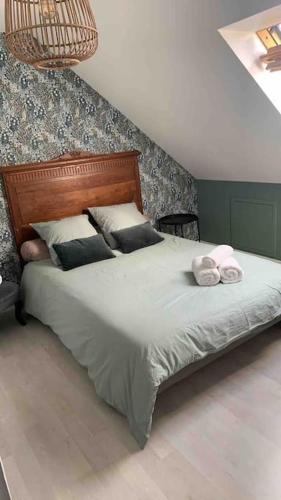 une chambre avec un grand lit avec deux serviettes dessus dans l'établissement Aux portes du circuits, à Yvré-lʼÉvêque