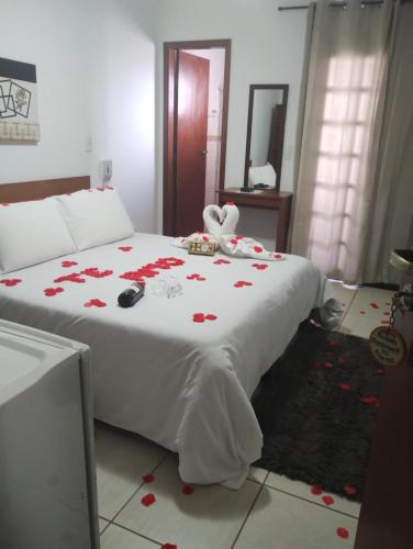 a bedroom with a bed with red roses on it at Pousada steppenwolf a 1 km do centro in Monte Verde