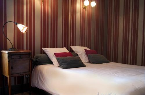 a bedroom with a bed with pillows on it at Logis Hotel - Restaurant La Marbrerie in Caunes-Minervois