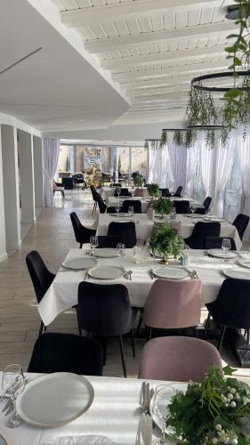 a dining room with white tables and chairs at Casa Budisteanu in Focşani
