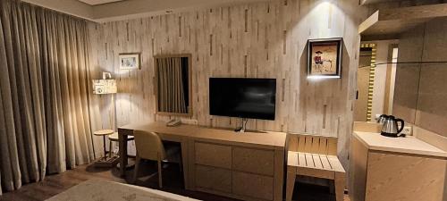 a room with a desk with a television on the wall at Dream Land Oasis 14-704 apartment in Chakvi