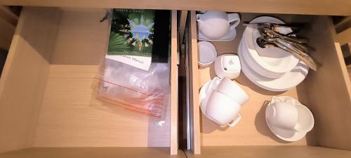 a cupboard with white dishes and a bag of food at Dream Land Oasis 14-704 apartment in Chakvi