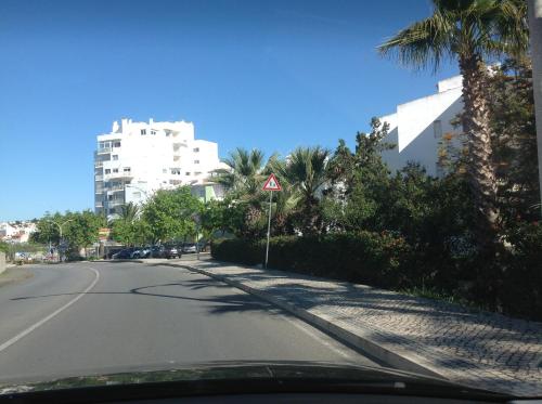 an empty street with palm trees and a building at D João Xavier Guesthouse in Lagos