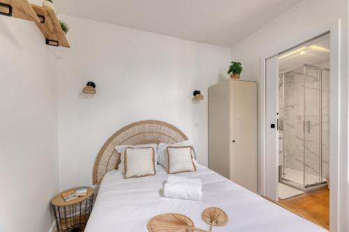 une chambre avec un grand lit avec des draps blancs dans l'établissement Studio cosy - entre le Château des Ducs et le Jardin des Plantes, à Nantes