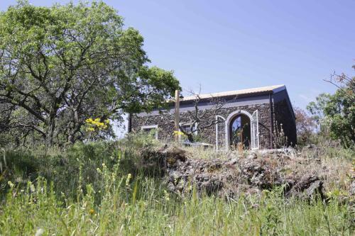 an old brick building in a field of grass at EcoAgriturismo Notti Stellate Etna Mare in Mascali