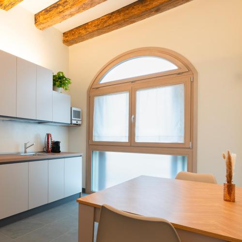 a kitchen with a wooden table and a window at Antica Corte Lugo in Lugo