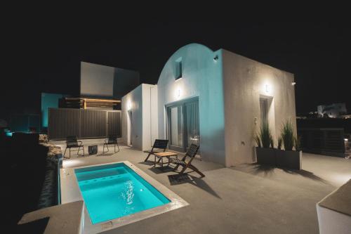 a swimming pool on the roof of a house at night at Uranides Luxury Suites in Santorini
