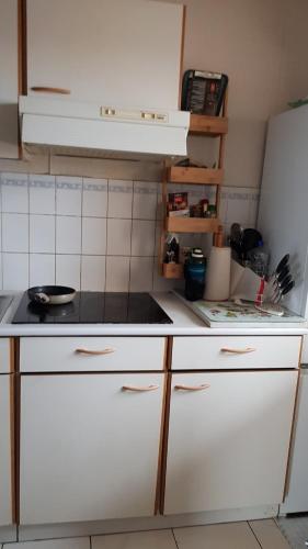 une cuisine avec des armoires blanches et un réfrigérateur blanc dans l'établissement 2 bedroom apartment, beautiful view, à Arcachon