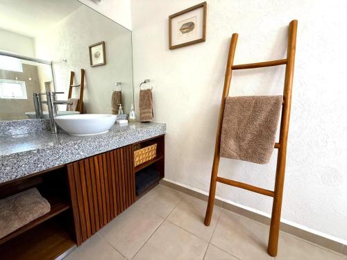 une salle de bain avec un lavabo et un miroir dans l'établissement Villa Tostados Acapulco Diamante, à Acapulco