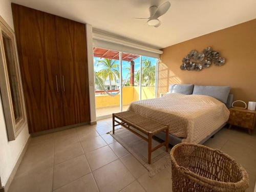 une chambre avec un lit, une chaise et une fenêtre dans l'établissement Villa Tostados Acapulco Diamante, à Acapulco