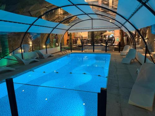 维拉卡洛斯帕兹Hotel El Paraiso Boutique的建筑物内有蓝色水的大型游泳池
