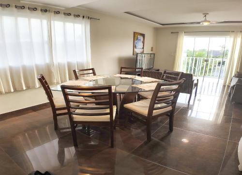 a dining room with a glass table and chairs at Moradas do Campeche CSABC in Florianópolis