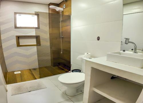 a bathroom with a toilet and a shower and a sink at Moradas do Campeche CSABC in Florianópolis