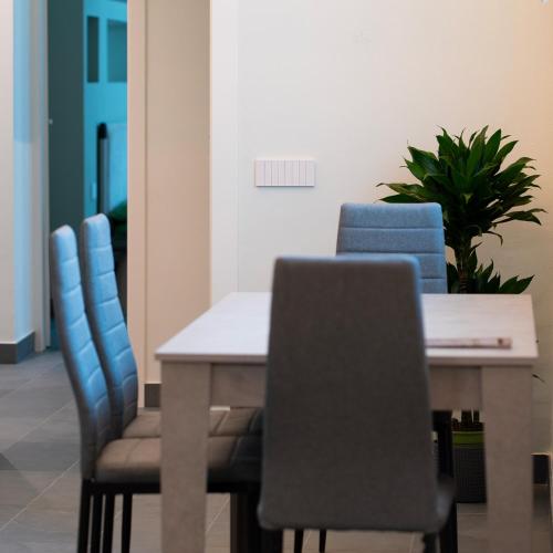 a dining room table with blue chairs and a plant at Antica Corte Lugo in Lugo