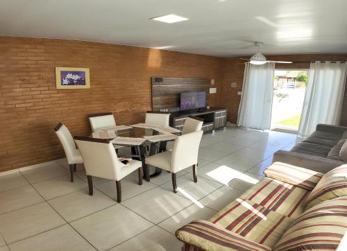 a living room with a table and chairs and a couch at Moradas do Campeche CSABC in Florianópolis