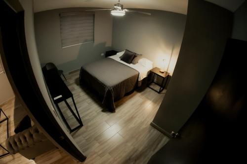 a bedroom with a bed and a table and a ceiling at Departamento Rosa & Chocolate 4A in Matehuala