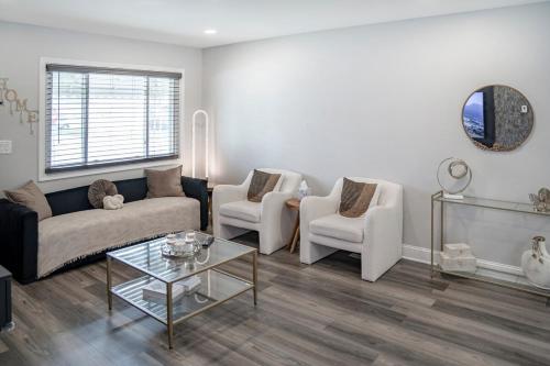 a living room with a couch and two chairs and a table at Elegant Home Mins from DTW in Dearborn Heights