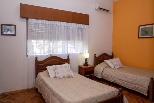 a room with two beds and a window with at Posada de Campo San Cono in Mercedes